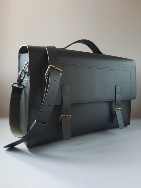 Cartable en cuir noir avec bandoulière réglable, vue latérale