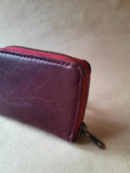Détail couture main porte-monnaie cuir basane rouge bordeaux