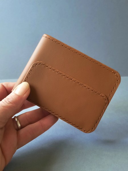 Portefeuille en cuir Le Galet gris tenu en main - Emmanuelle Olivier Maroquinerie